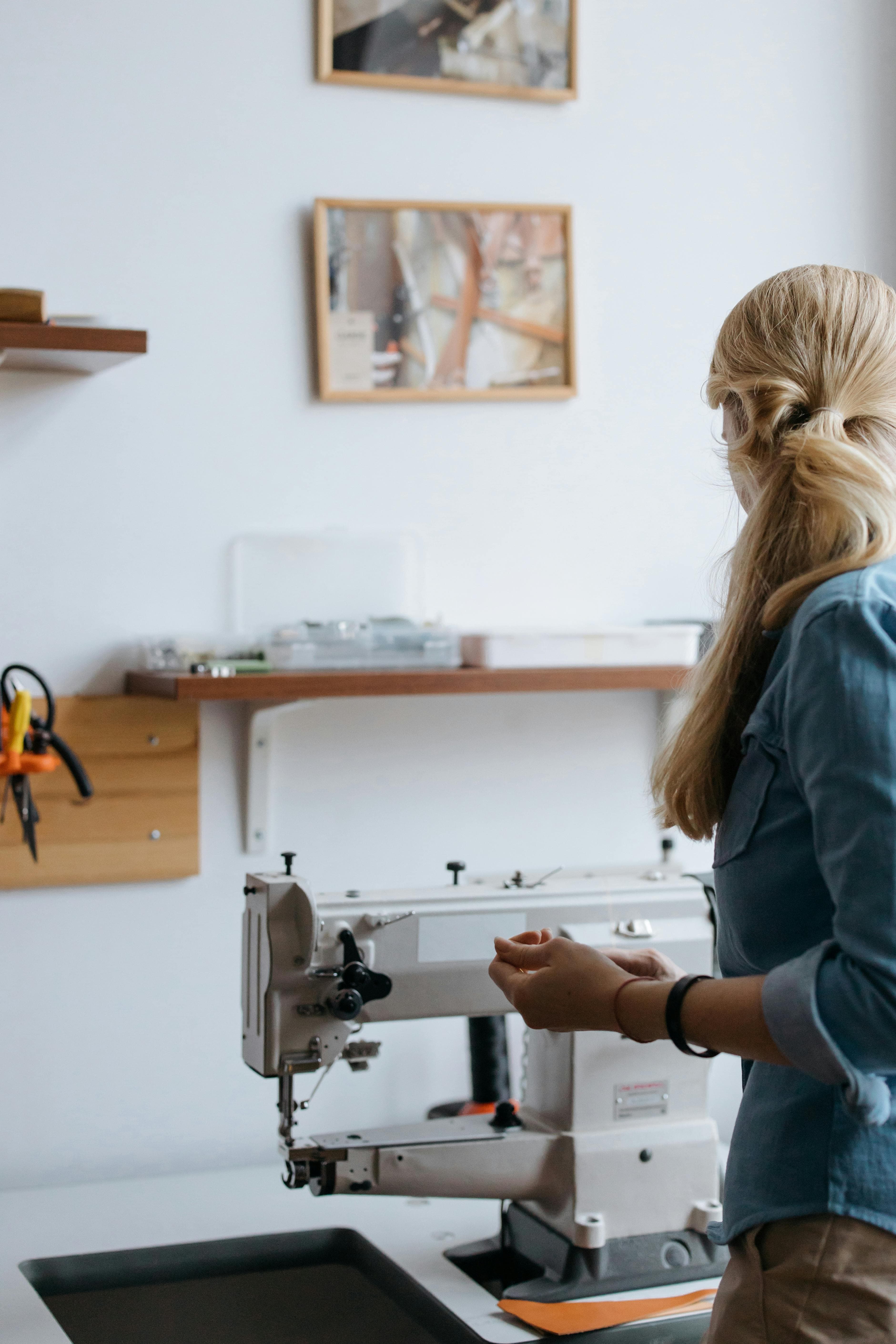 The Paris atelier: a seamstress at work, lit by afternoon window light.